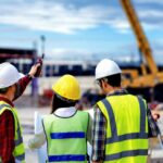 surveyor engineer with theodolite at construction site during surveying work.engineer and architect working at construction site with blueprint